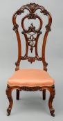 A Victorian carved rosewood nursing chair The ornate scrolling top rail above a carved and pierced
