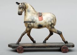 A 19th century carved and painted wood and papier mache child’s pull toy Modelled as a cantering