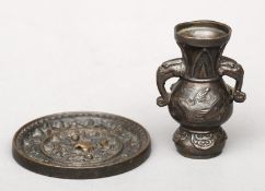 A small twin handled Chinese bronze vase and a small Chinese bronze circular mirror, both possibly