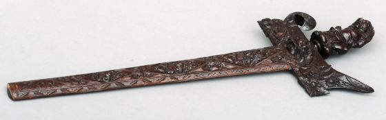 An Indonesian kris The hardwood handle and scabbard extensively carved with mythical beasts and