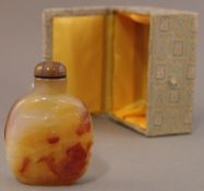 A Chinese carved agate snuff bottle and stopper Decorated with the figure of a carp, boxed. 7.5