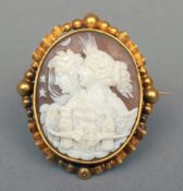 A Victorian unmarked yellow metal framed cameo brooch The front carved with a classical scene