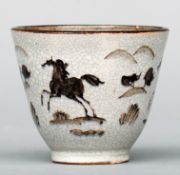 A Chinese crackle glazed tea bowl Decorated to the exterior with horses in a landscape. 8 cms high.