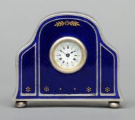A small silver and enamel decorated clock The blue enamelled case with gilt detail, the dial with