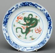 A Chinese Ducai dish Decorated with dragons chasing a flaming pearl, the underside with blue painted