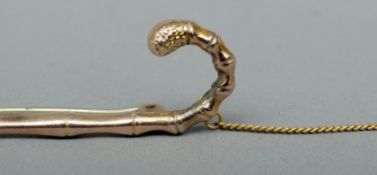 A 9 ct gold bar brooch Formed as a walking stick. 7 cms wide.