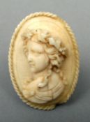 A 19th century carved ivory brooch The ropetwist bordered oval body carved in relief with a young