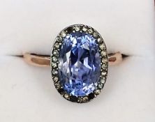 A Victorian unmarked gold ring The central blue stone, possibly a tourmaline, bordered by a band