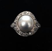An Art Deco platinum, pearl and diamond ring The large central pearl bordered by a row of diamonds