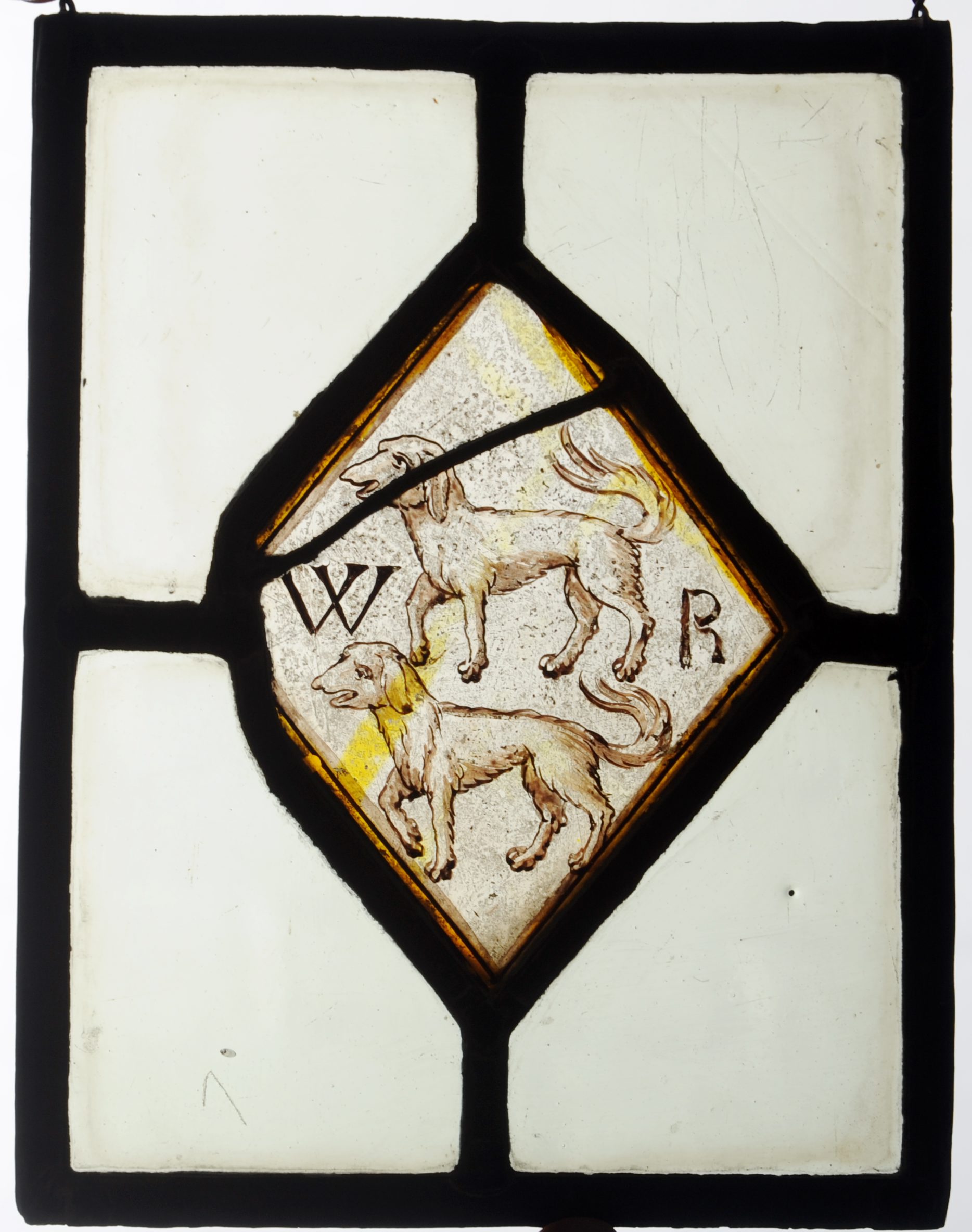 A 17th century stained and leaded glass panel The central lozenge decorated with a pair of dogs