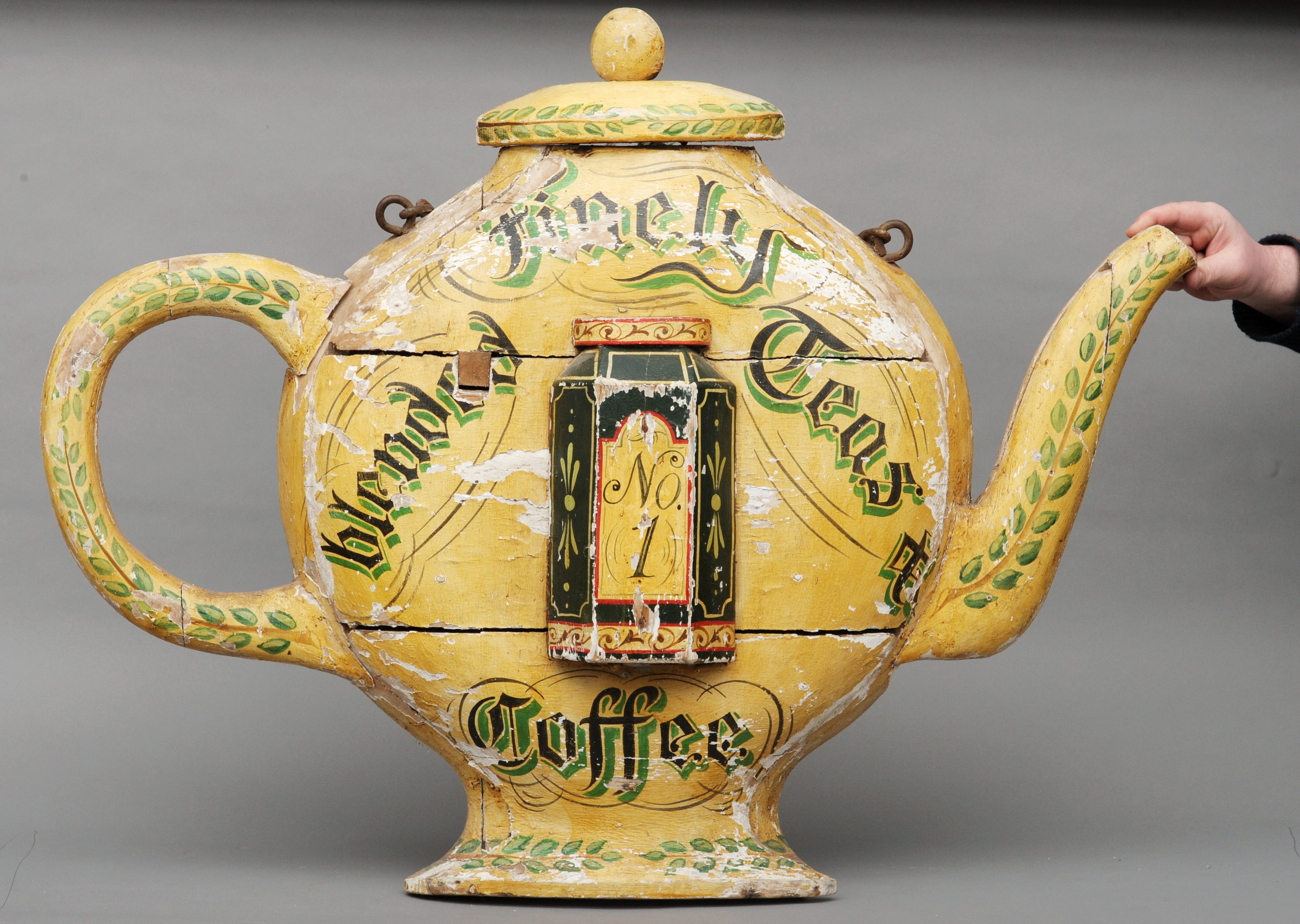 A late 19th/early 20th century painted carved wooden tea shop sign Formed as teapot, the front