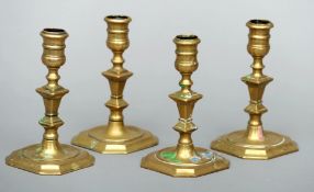 A set of four 18th century brass candlesticks, possibly American The bulbous sconces supported on