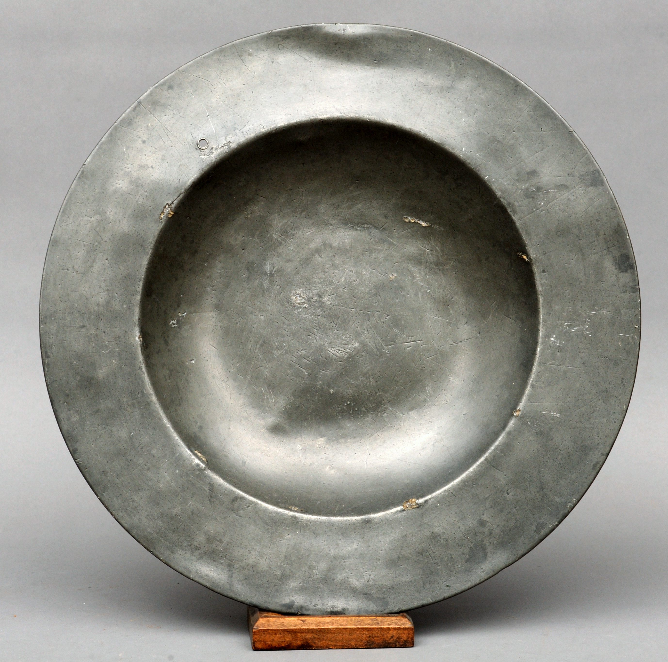 An early pewter broad rimmed charger Of dished circular form with touch marks to the reverse. 41 cms