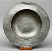 An early pewter broad rimmed charger Of dished circular form with touch marks to the reverse. 41 cms