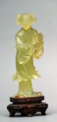 A Chinese carved jade figure modelled as a lady in flowing robes Standing on a carved and pierced