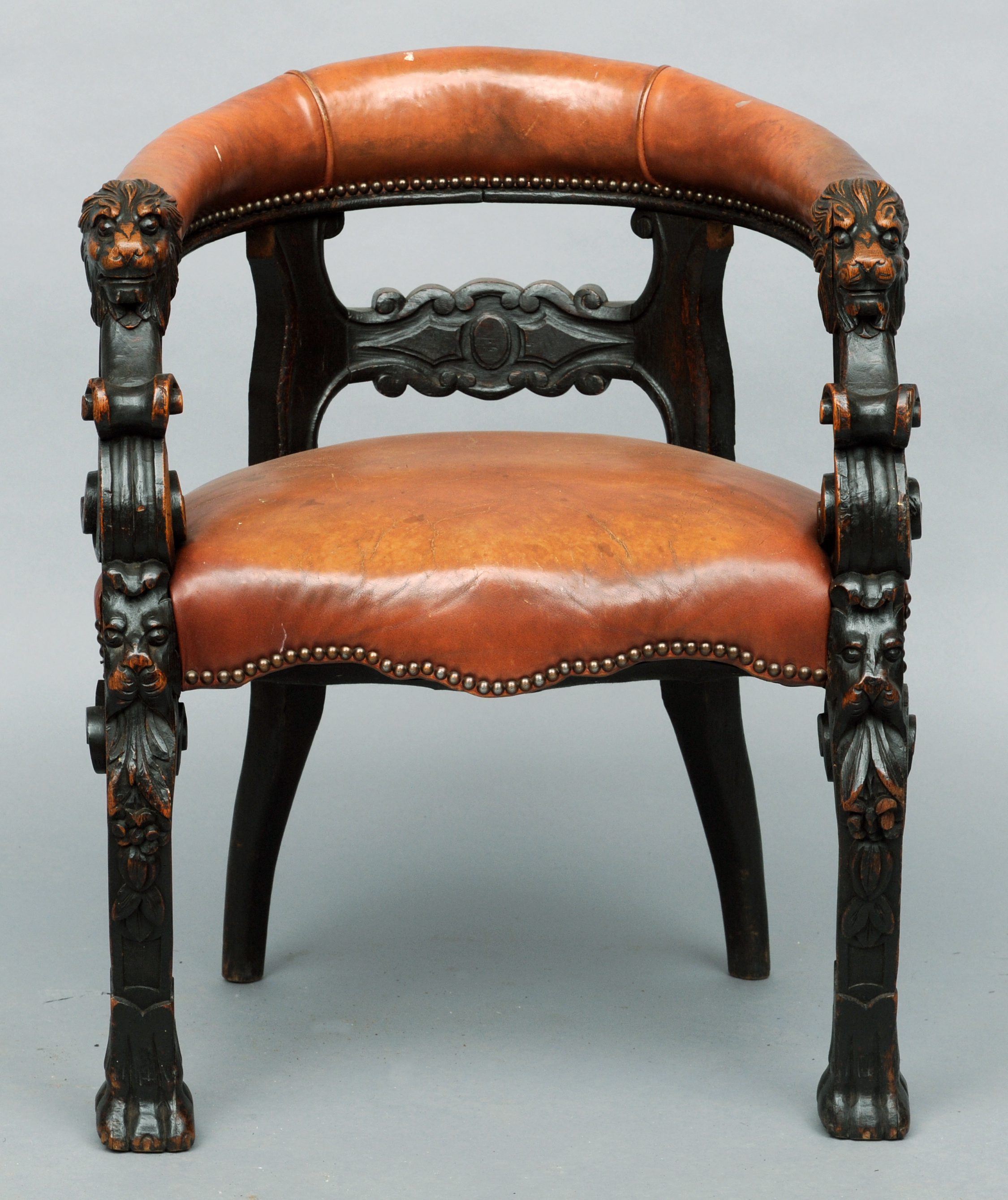 A 19th century leather upholstered carved oak tub chair The leather padded back rail above a