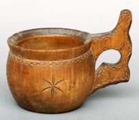 A 19th century carved willow cup With shaped handle and chip carved decoration. 14 cms high