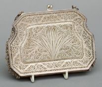 An unmarked white metal filigree purse With extensive scrolling decoration, supported on two flat