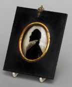 An early 19th century reverse painted bowed glass painted silhouette portrait miniature of a