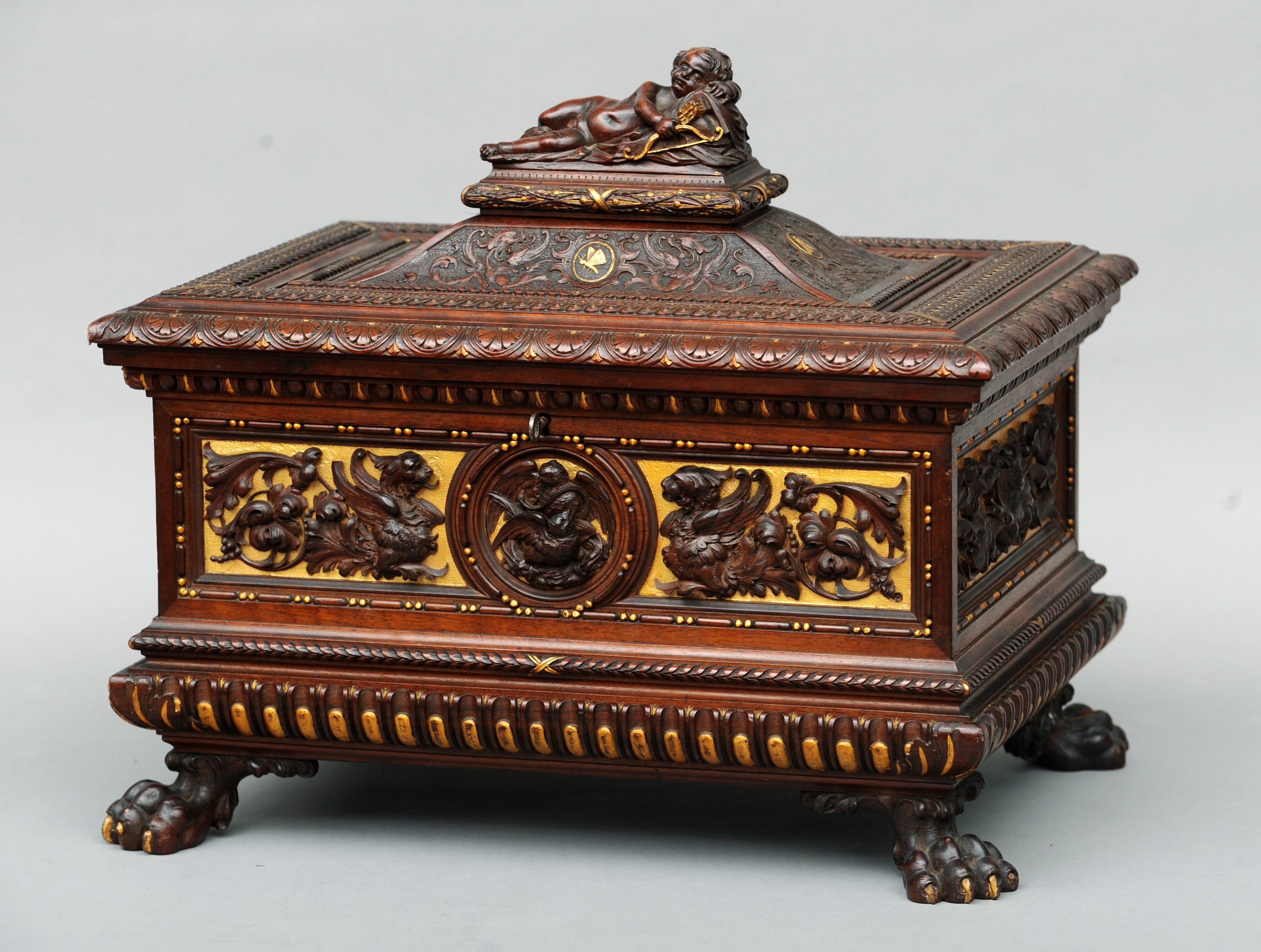 A 19th century Italian carved walnut casket with gilt detail The hinged domed rectangular top