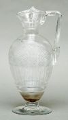 A 19th century cut glass claret jug Of baluster form, with angular handle, the body diamond relief