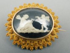 A Victorian unmarked yellow metal framed brooch The oval central panel decorated with a fairy and