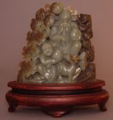 A Chinese carved nephrite boulder Decorated in high relief with figures seated amongst pine trees,