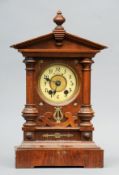 A walnut cased polyphone style musical mantel clock The dial with Arabic numerals above a musical