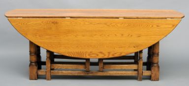 A large 20th century oak drop leaf table The hinged twin flap top above the double gateleg action,
