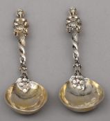 A pair of Continental white metal spoons Each with figural finial, spiral cast stem and plain bowl