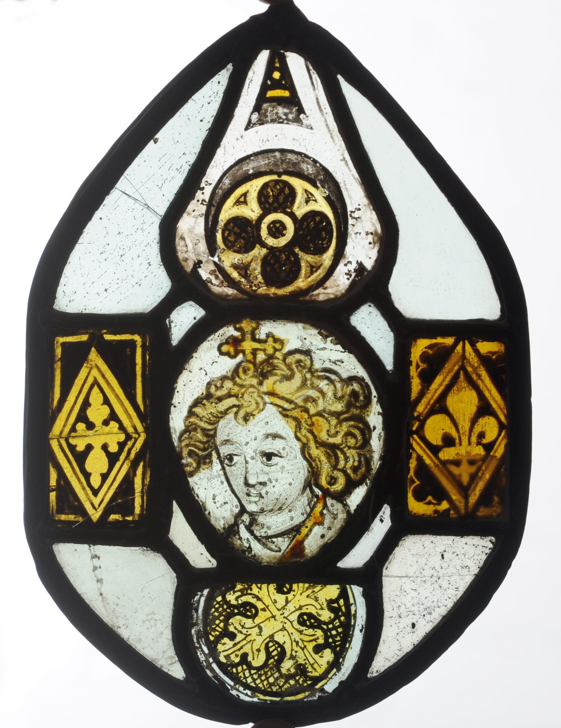 A 14th/15th century stained glass panel Of tear form centred with a portrait roundel of a saint,