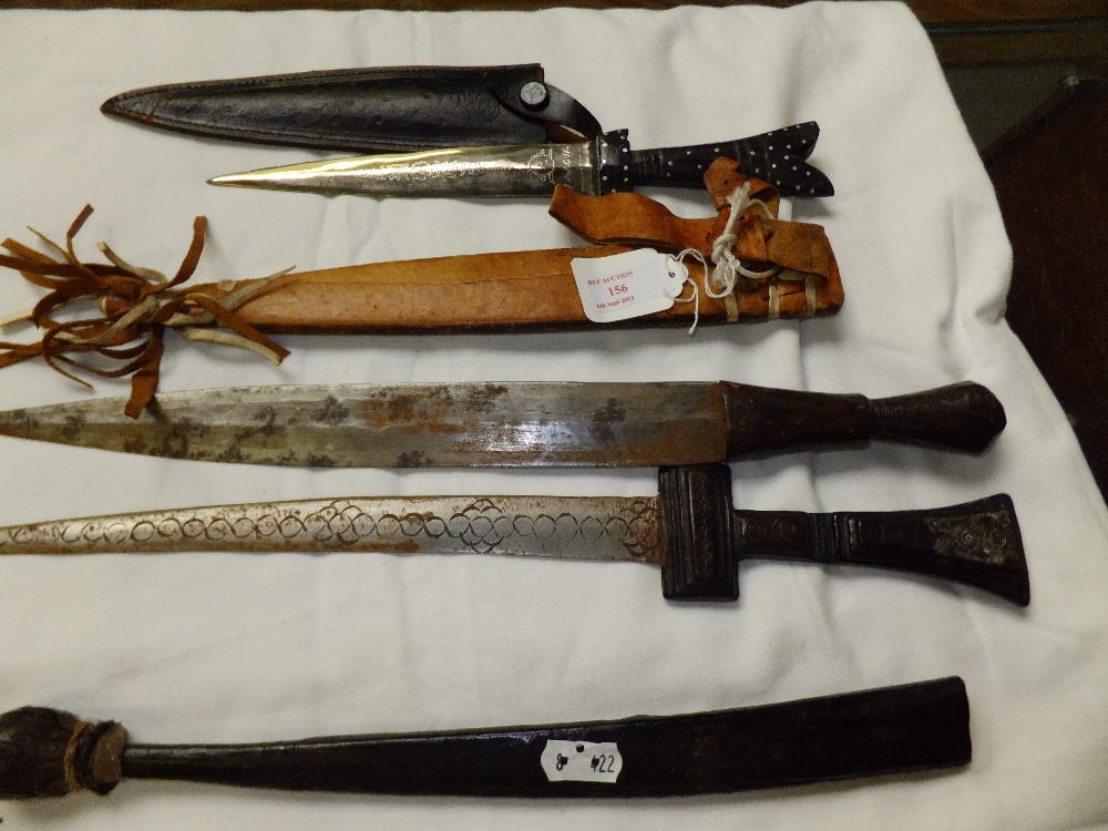 Three Islamic daggers in leather sheaths
