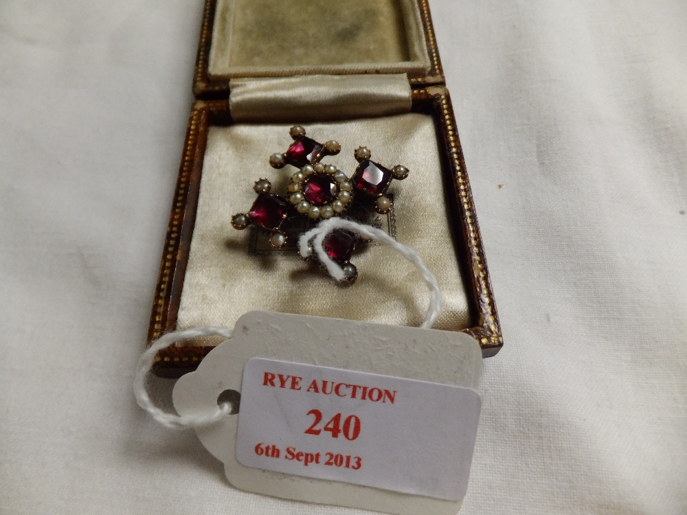 A Victorian yellow metal brooch set with garnets and seed pearls