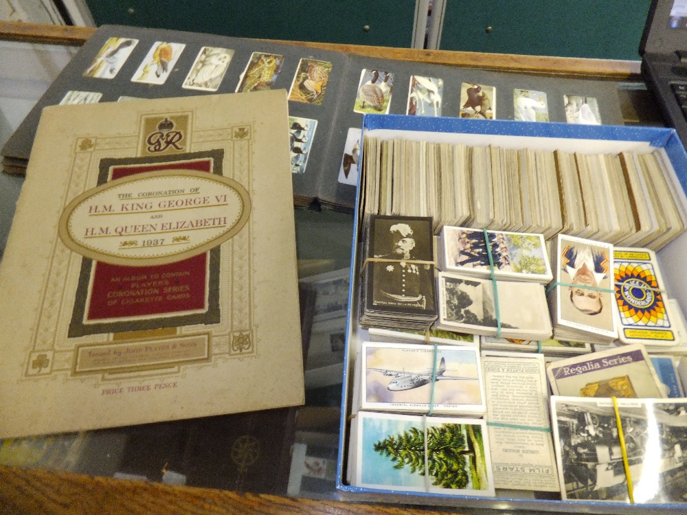 A box containing a mixed selection of cigarette cards and tea cards on railways, celebrities, the