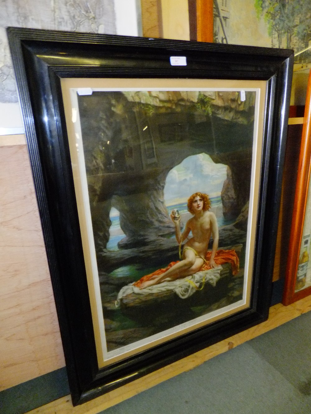 A vintage Pears soap annual print depicting a nude lady on a rock, mounted in a black frame 17" x