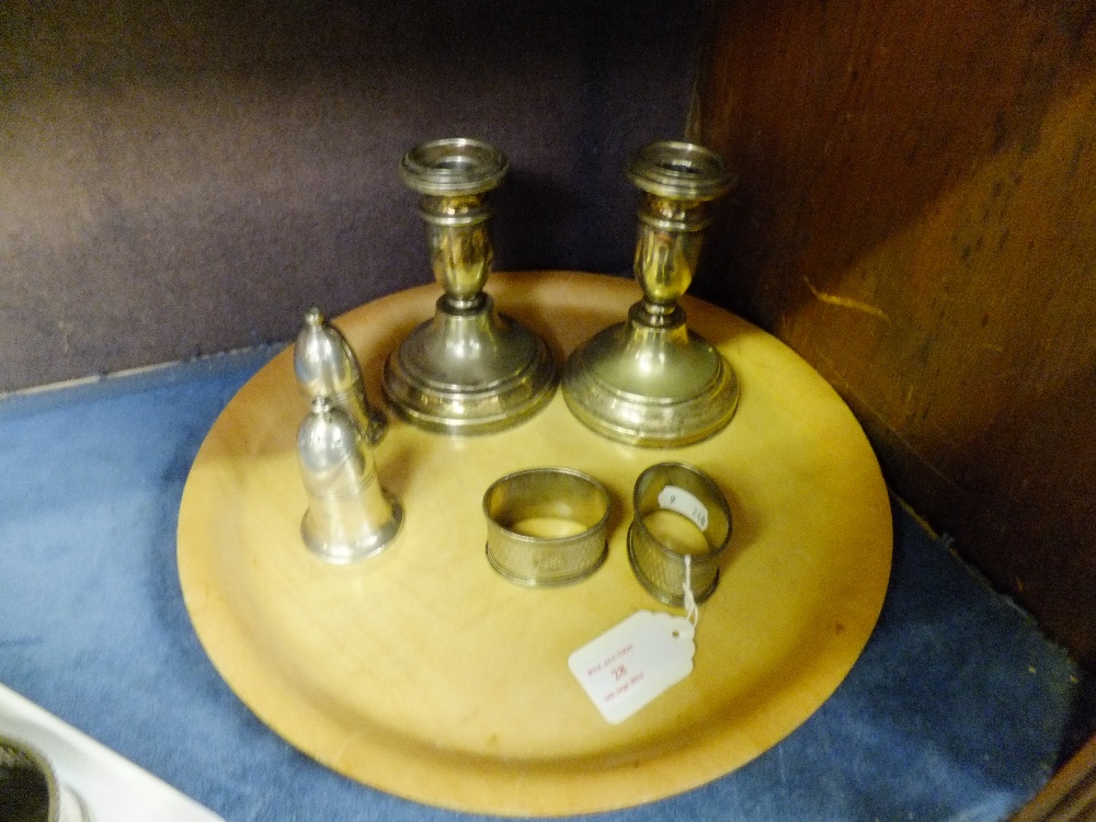 A pair of candlesticks, salt and pepper pot and a pair of Birmingham silver napkin rings