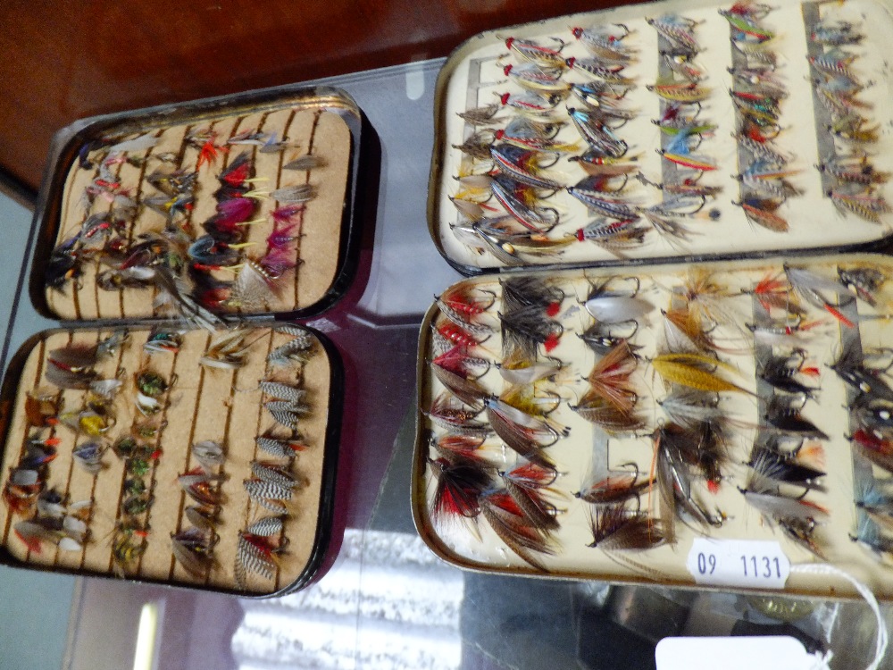 Two vintage metal cases containing fly fishing feathers