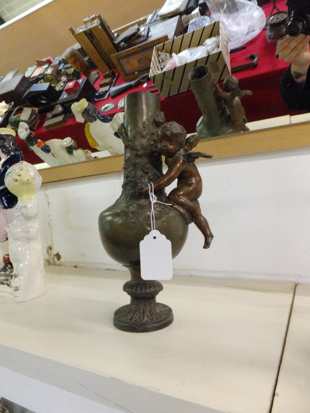 A spelter vase with applied cherub decoration