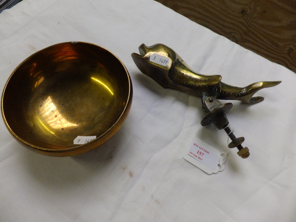 A heavy brass dolphin door knocker and a temple bowl