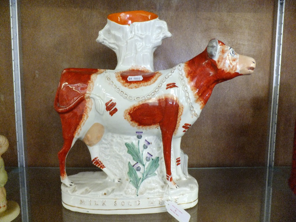 A Staffordshire flat back figure of 'Milk sold here' cow spill vase 14"