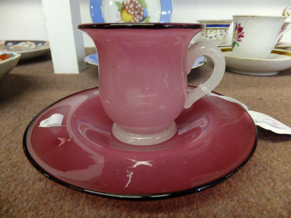 An 1860/70's bell shaped cup and saucer having rose coloured staining and black rim with opaque
