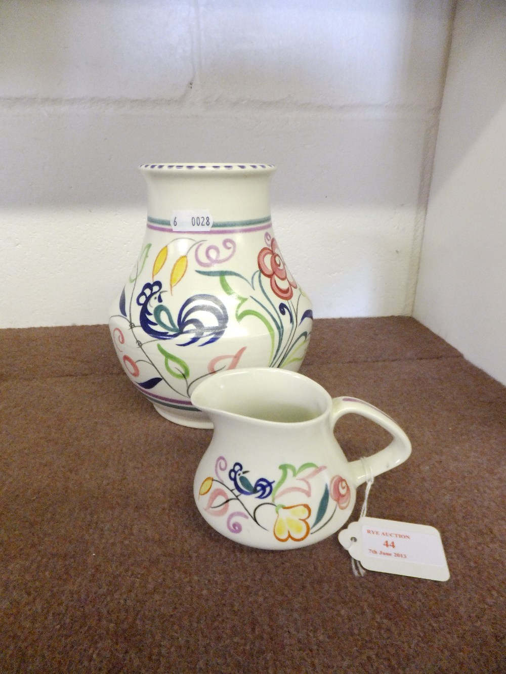 A Poole Pottery vase and cream jug with blue bird decoration