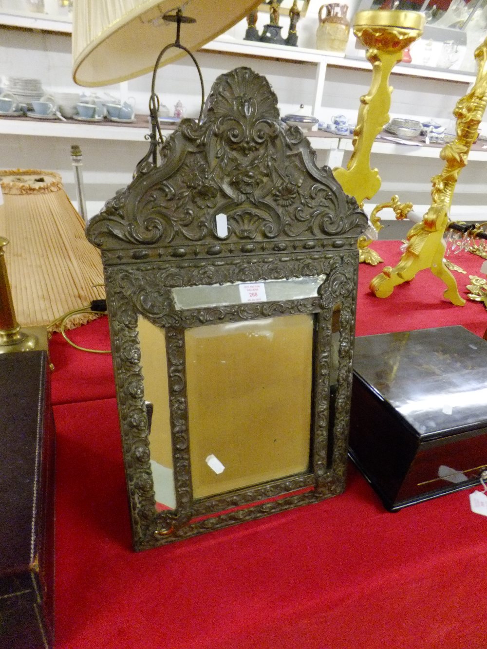 An ornate Victorian brass-framed bevelled dressing mirror with embossed decoration and table