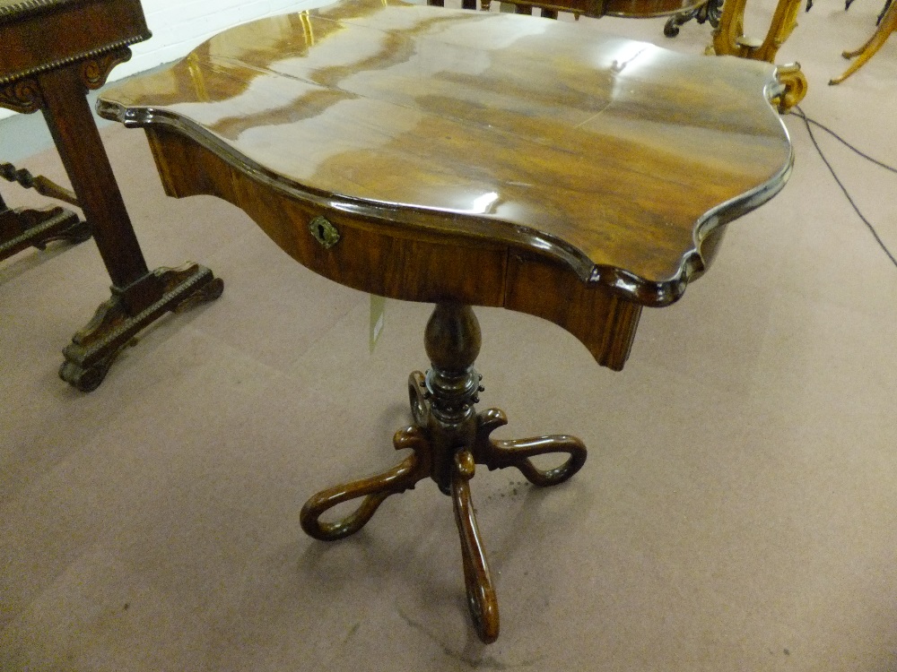 A mid 19th century walnut sewing table having single frieze drawer baluster shaped column resting on
