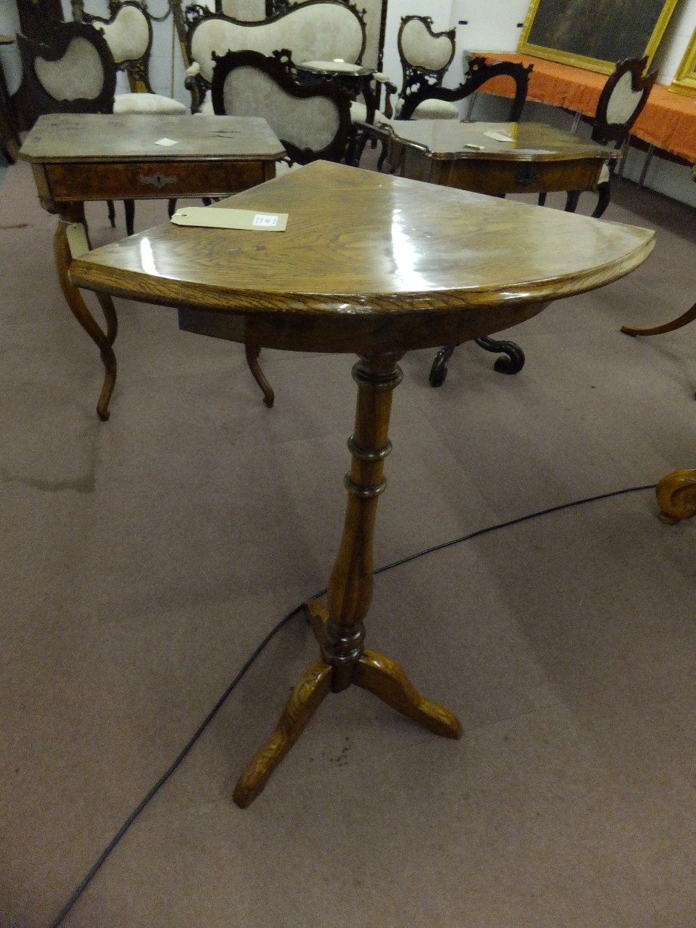 A mid 19th century oak corner table with bow front baluster shaped column with three splayed legs