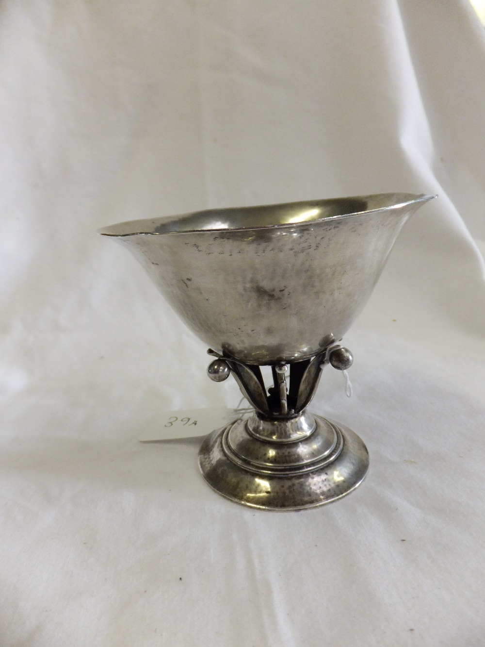 A Georg Jensen sterling silver chalice resting on group of fern leaves and circular stepped base