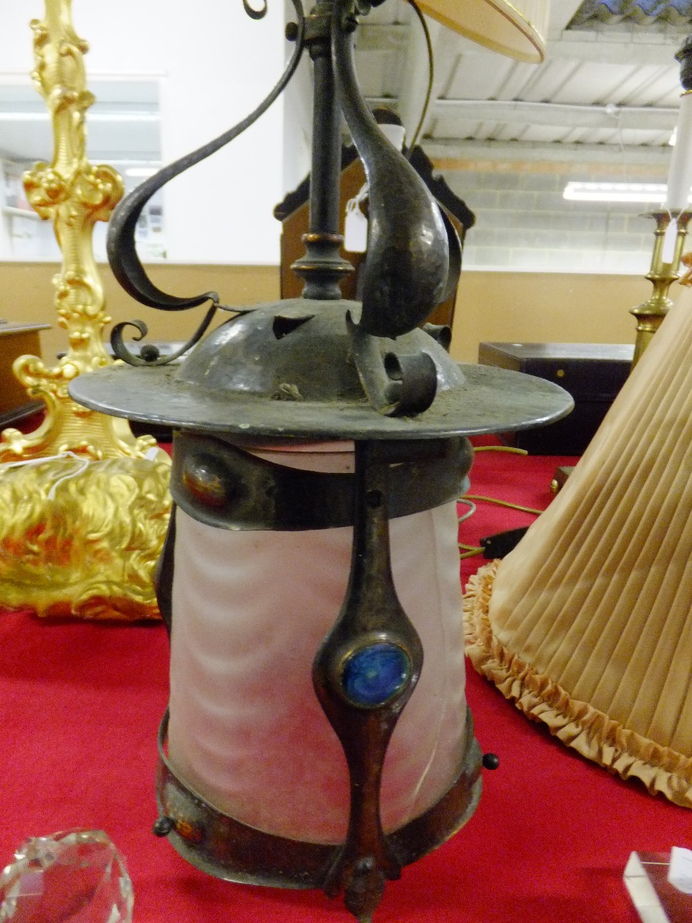 An Art Nouveau beaten copper lamp having frosted glass shade with Ruskin type enamelled lozenge