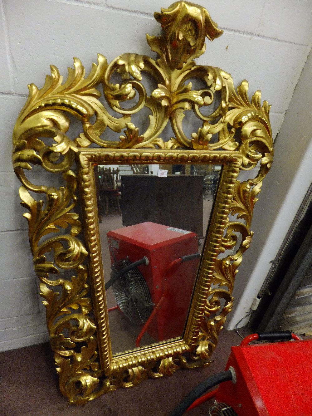 A 19th century gilt baroque tapering framed mirror having ornate carved scroll work the mirror