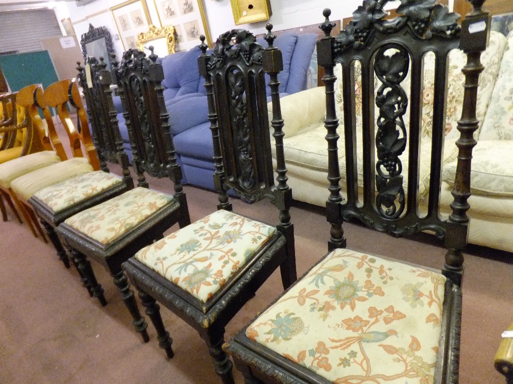 A set of four Victorian  oak hall chairs with grape and vine carved backs and upholstered drop in