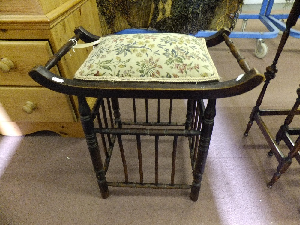 An Arts and Crafts spindle framed piano stool with upholstered seat